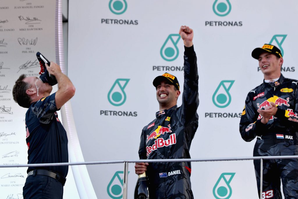 Christian Horner, Daniel Ricciardo and Max Verstappen from Red Bull Racing share a "shoey" on the podium at the 2016 Malaysia GP